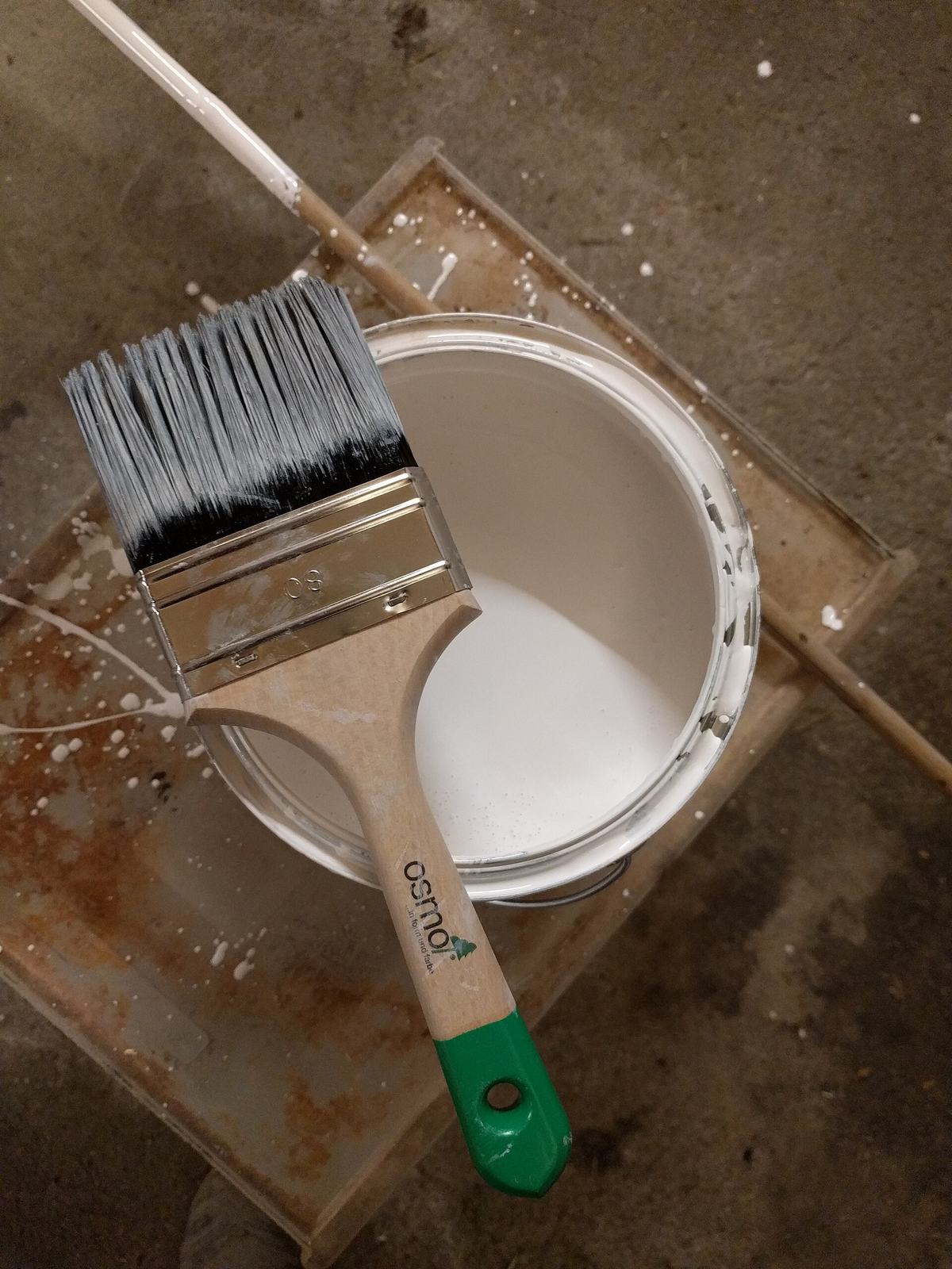 Open pot witte verf met een kwast erop